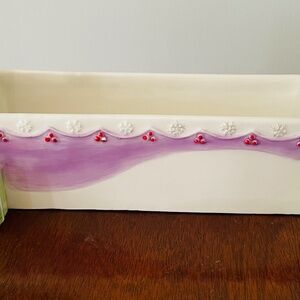 A modern ceramic planter decorated with gift boxes and festive accents, Avon